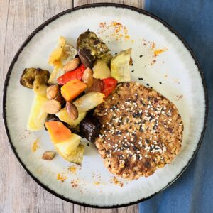 Hamburguesa de porotos adzuki, nueces y yamaní con verduras horneadas y almendras confitadas
