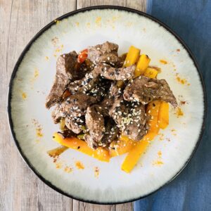 Wok oriental de lomo, jengibre y verduras con semillas de amapola