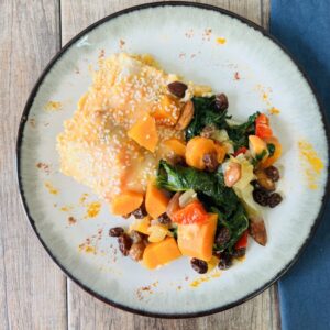 Salmón con salsa de vegetales sobre base de espinacas con almendras y pasas de uva